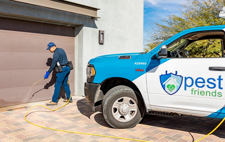 technician treating the outside of a home